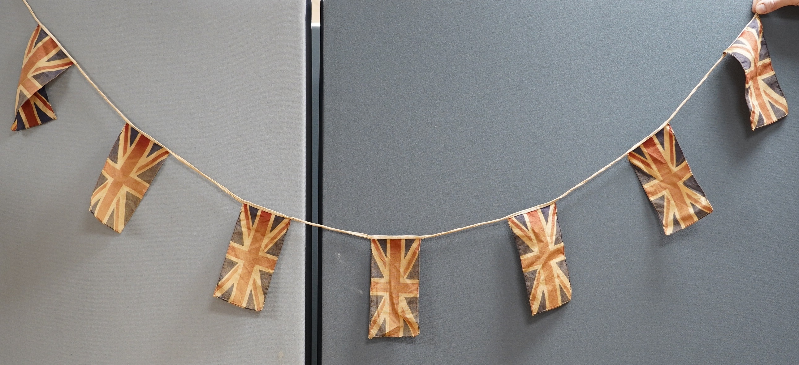 Eight mostly mid 20th century Union Jack flags, one celebrating Queen Victoria’s Diamond Jubilee, together with a Saint George’s cross and a string of Union flag bunting. Condition - poor to good